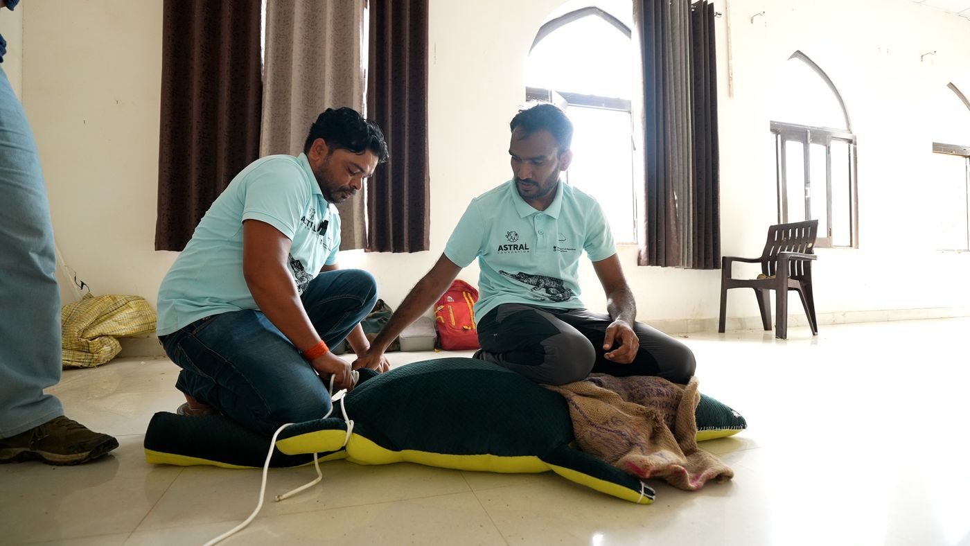 Jailabdeen and Raghavendra use a plush model to demonstrate the safest way to restrain a marsh crocodile during a rescue.